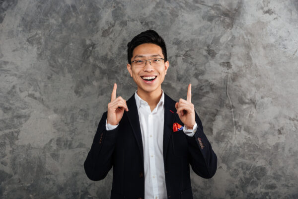 Portrait of a happy young asian man dressed in suit