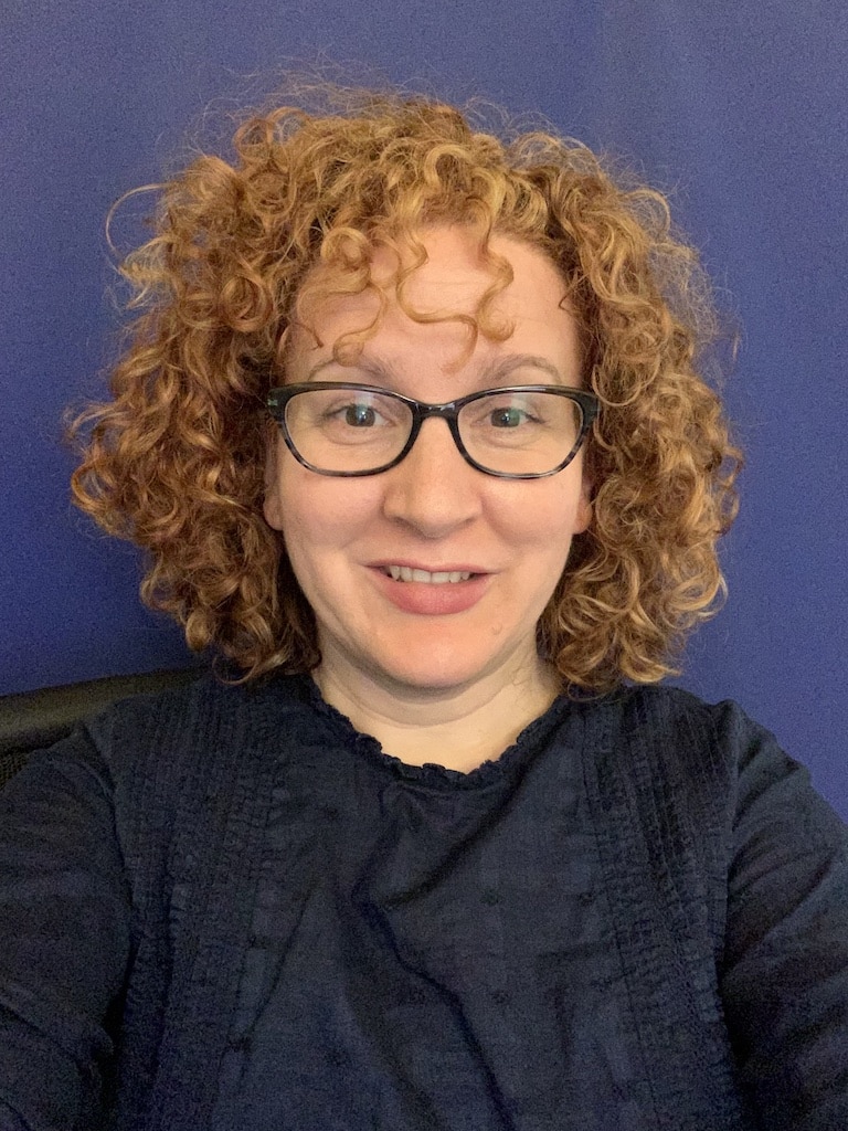 Audrey Bastian wearing a blue shirt. Reddish brown hair