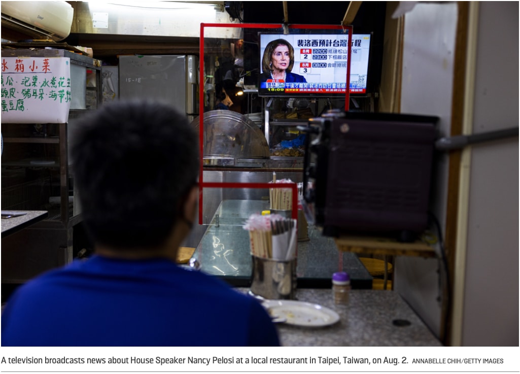 Taiwanese person watches Pelosi on TV.