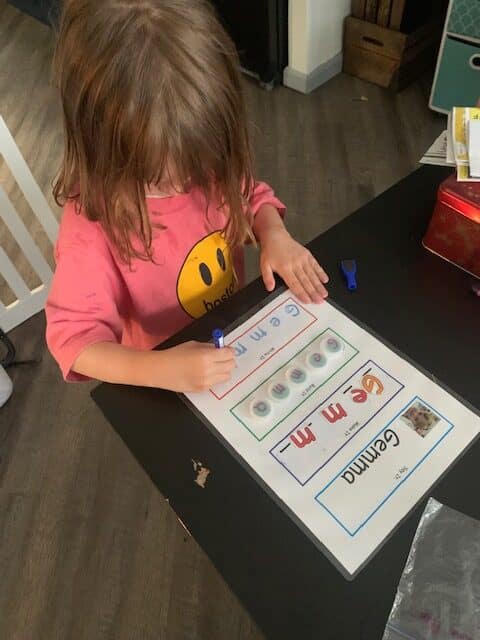 Gemma writes the letters in her name. Gemma traces the letters of her name in blue.